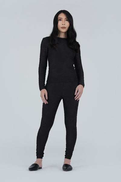 Front View of a fitted, long sleeve conwave knit top with crew neck and horizontal wave pattern matching looks of cooled lava.